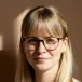 Portrait of a woman with blonde hair and glasses